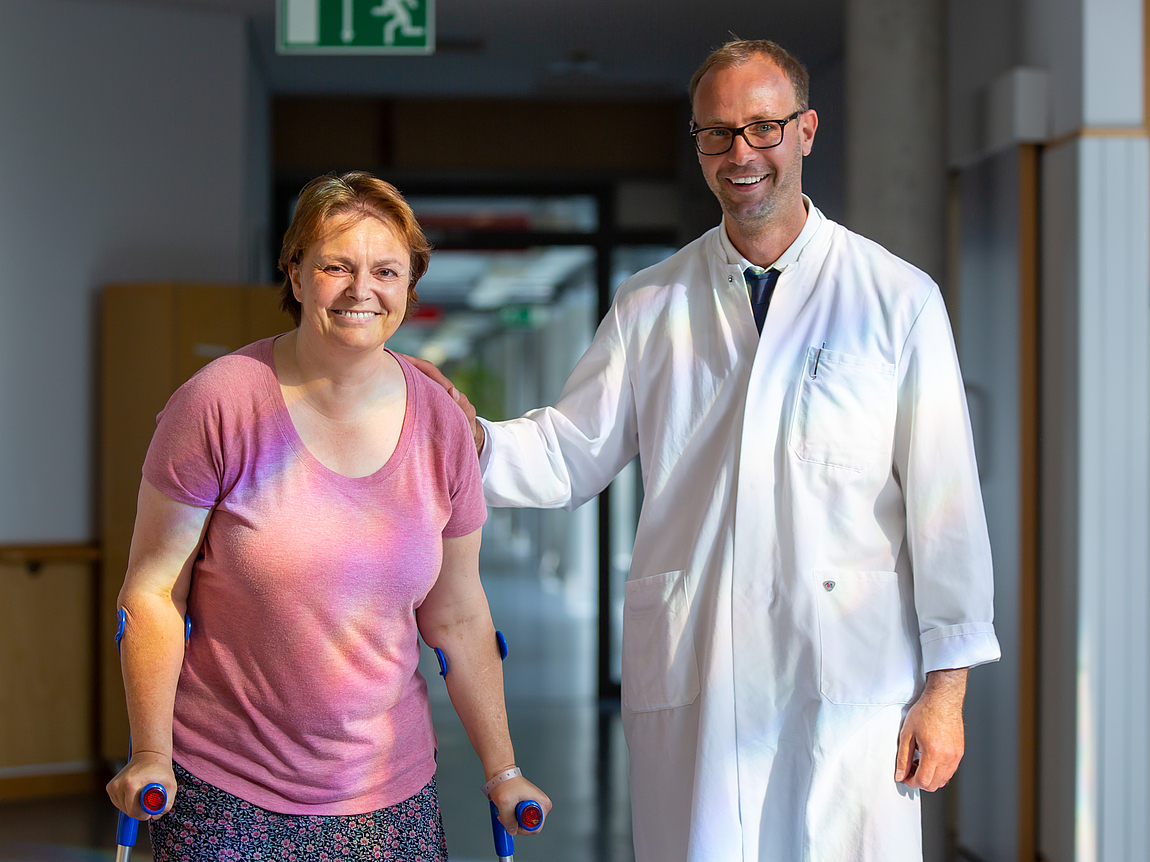 Arzt begleitet Patientin bei Gang auf Krücken