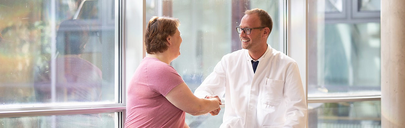 Arzt schüttelt einer Patientin die Hand