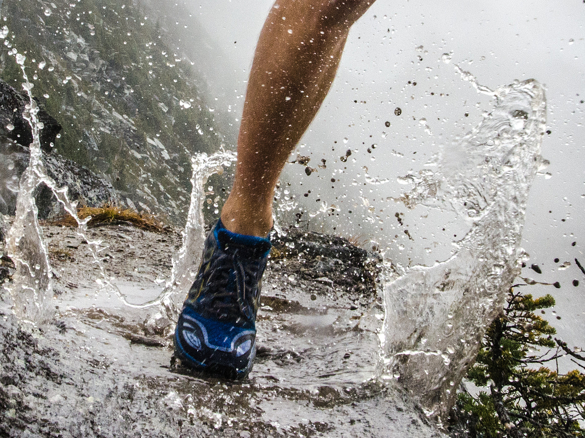Bein eines Joggers auf nassem Untergrund